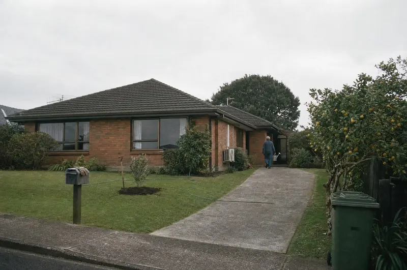 A young pōhutukawa just planted on the front lawn of a brick-and-tile house in Howick, Auckland, the spade still in the soil as the owner walks up the drive